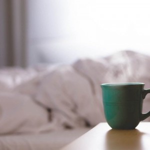 coffee-cup-on-table-with-bed-in-background